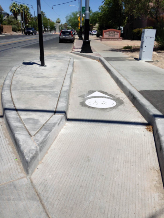 This bicycle cutout on the southern side of University just east of Fourth Avenue allows cyclists to cross the tracks at a more optimal angle and then use the channel to merge onto University. 