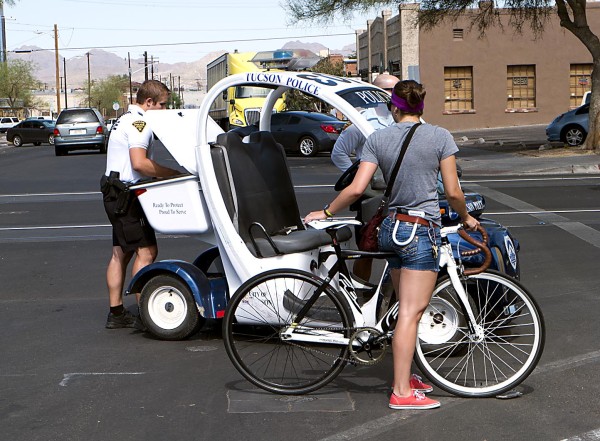 A cyclist gets a ticket along the streetcar route on Wednesday, July 2, 2014.